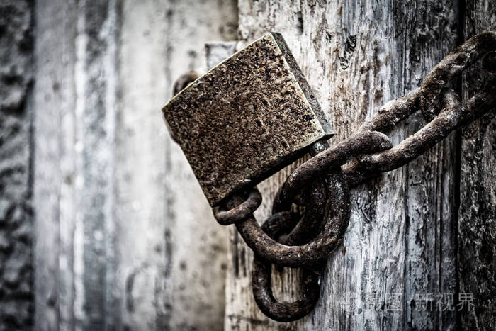 在一个非常古老的木门生锈的挂锁细节