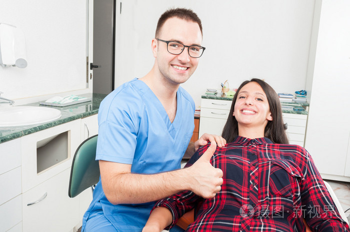 牙医与他微笑显示拇指的病人