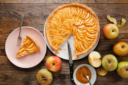 传统的苹果馅饼馅饼, 奶油馅和果酱盖在一个简陋的木桌上。顶部视图