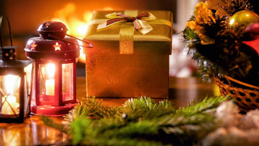 圣诞节礼物和魔术灯笼的特写图片反对燃烧的壁炉