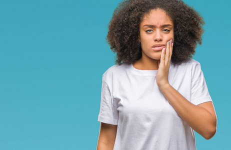 年轻的美国黑人妇女在隔绝的背景下抚摸嘴与手与痛苦的表达由于牙痛或牙齿病症在牙。牙医概念