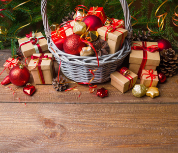 圣诞节或新年背景 带彩色玻璃玩具的篮子装饰品和木质背景礼品