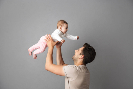 白人父亲的形象抱着他的小宝宝在手上孤立的灰色背景