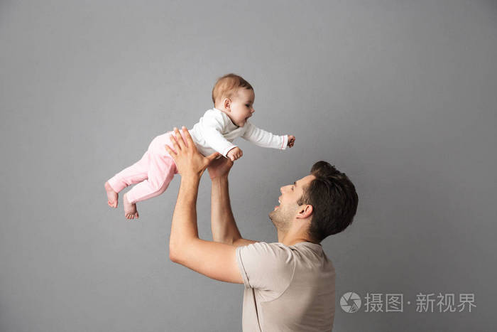 白人父亲的形象抱着他的小宝宝在手上孤立的灰色背景