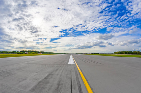 机场跑道到地平线和风景如画的云彩在蓝色的天空