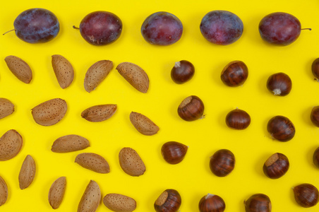秋天的有机坚果和水果在黄色背景上的设置
