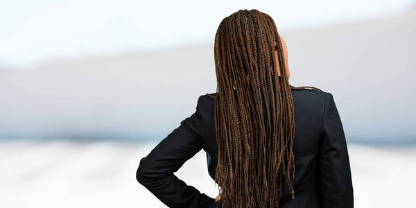 一个年轻的黑色商业妇女的肖像显示回来, 摆姿势和等待, 回头看
