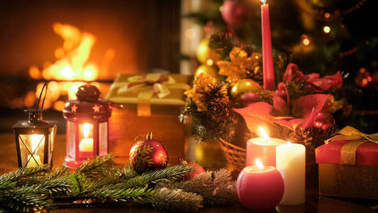 特写色调照片的圣诞装饰品在木桌上反对燃烧壁炉