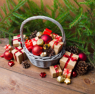 圣诞节或新年背景 带彩色玻璃玩具的篮子装饰品和木质背景礼品