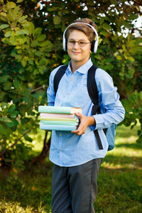 可爱, 小男孩在圆杯子, 蓝色衬衣与背包存放书。教育学习回归学校理念