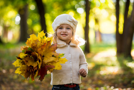 快乐的小女孩，在公园的秋天叶子在他们手中