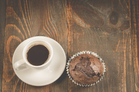 一杯黑咖啡和一块巧克力松饼一杯黑咖啡和一块巧克力松饼放在一张深色的木桌上。顶部视图和 copyspace