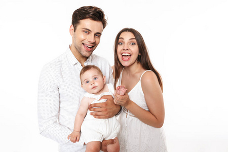 一个微笑的年轻家庭的肖像与他们的小女婴孤立在白色背景