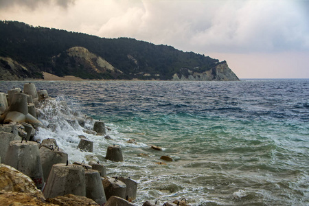 美丽的日出在海在风景如画的地中海 Ereikoussa 海岛在希腊。从 Ereikoussa 端口查看。大石块和混凝土砌块前景
