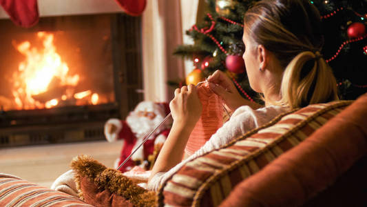 由壁炉和圣诞树的妇女针织围巾的色调形象