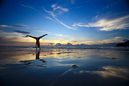瑜伽和海滩在海滩上冥想和瑜伽. 年轻女子正在做瑜伽照片