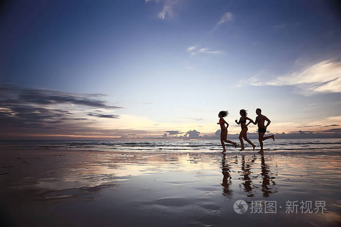 沿着海滩奔跑的运动员剪影暑假