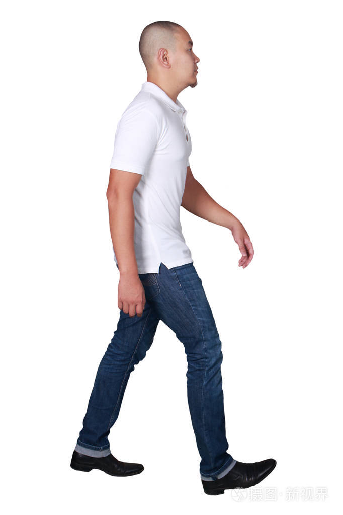 身着白色马球衫和牛仔裤行走的秃头亚裔男子的全身肖