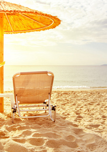 灰色秸秆伞上美丽的海滩和海洋用燃烧的太阳