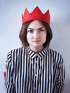 一个穿红色皇冠和条纹衬衫的女孩的照片肖像