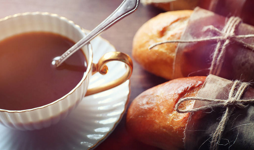 早餐的新鲜卷。面包与黄油一杯咖啡