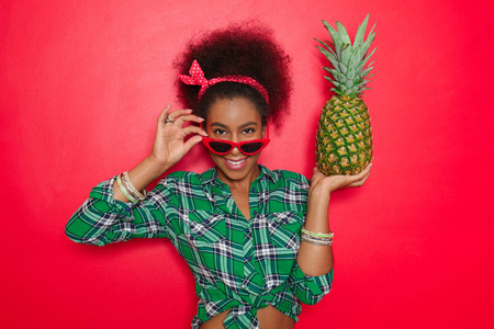 美丽的非洲裔美国妇女与菠萝在颜色背景