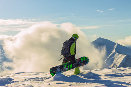 滑雪板 freerider 正站在白雪皑皑的山上, 在冬天的云层下