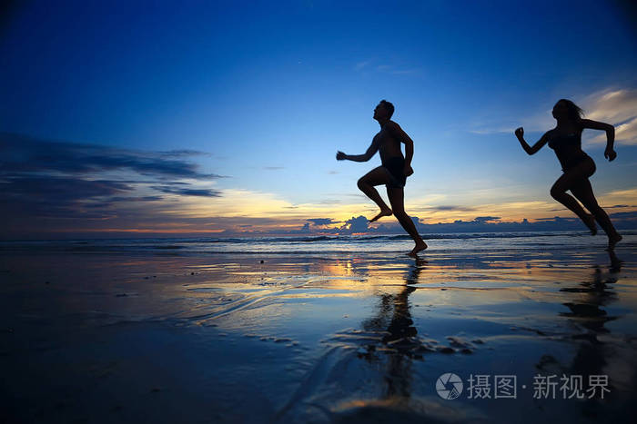 两名运动员沿着海滩奔跑的剪影, 暑假