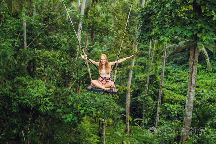 巴里岛丛林雨林秋千上的年轻女子游客