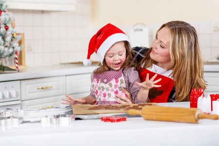 母亲和孩子小姑娘圣诞节烤姜饼图片