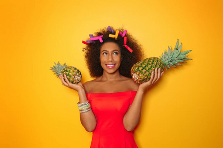 美丽的非洲裔美国妇女与菠萝在颜色背景