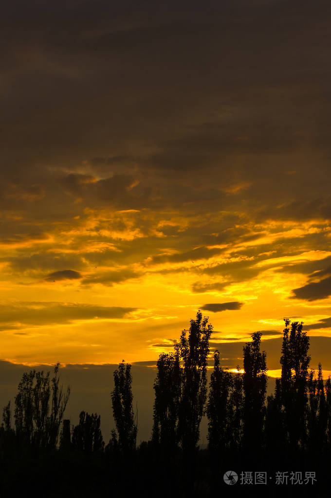 景观与戏剧性的光-美丽的金色日落与饱和的天空和云