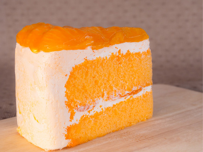 切菜板上的橙色蛋糕。在木桌上