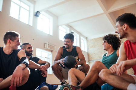 篮球运动员坐在球场上, 并有一个团队会议照片