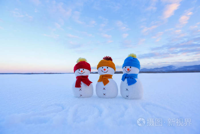 带着帽子和围巾的微笑雪人正站在雪地上.风景与山.美好的冬天为奇迹
