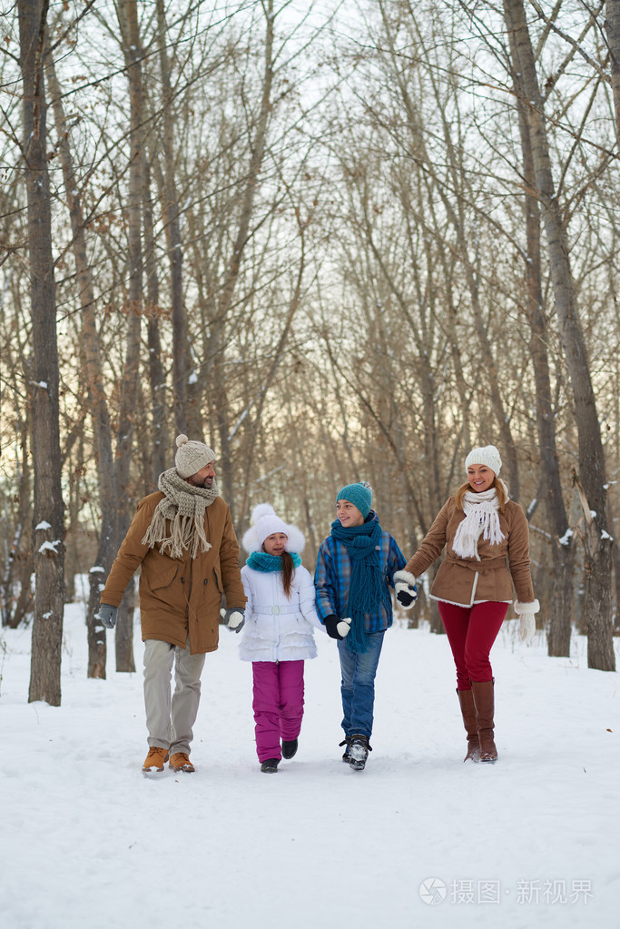 孩子和父母在冬季森林散步