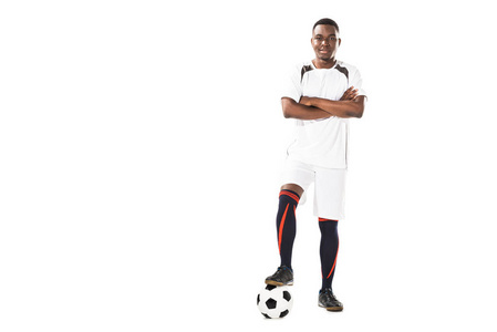 自信的年轻非洲裔美国足球运动员站在交叉的武器和微笑着在白色的相机隔离