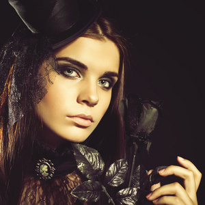 时尚年轻女子捧着黑玫瑰,万圣节晚会 2016照片