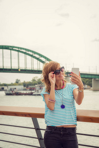 在河边的码头上使用手机的女孩