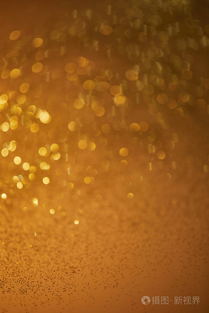金色的散景圣诞背景与下降闪闪发光的亮片
