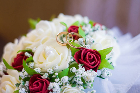 结婚戒指上一束红玫瑰。婚礼蜡烛新娘的花束。新娘袜