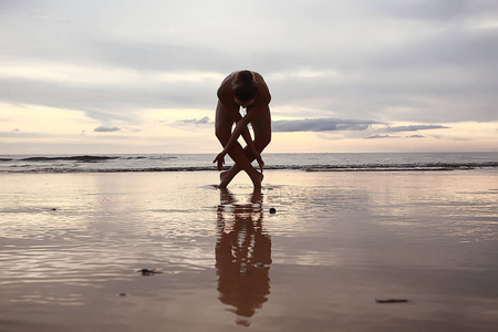 在海滩上冥想和瑜伽。 年轻女子正在做瑜伽
