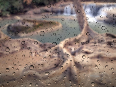 关闭玻璃背景下的雨滴。瀑布的焦点