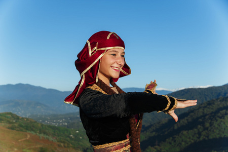 年轻女子跳舞格鲁吉亚民族服饰山户外夏日阳光明媚照片