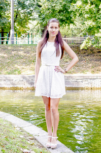 夏天公园里穿着白色连衣裙的年轻女孩