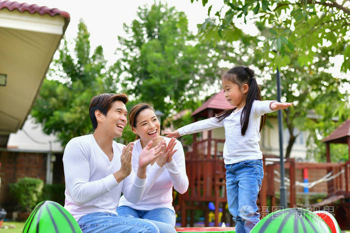 家庭在操场上做快乐的活动.有孩子的父母正在花园里玩耍.