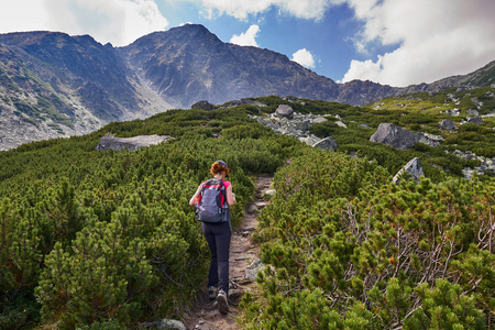 中年妇女与背包徒步旅行在山区的足迹白天