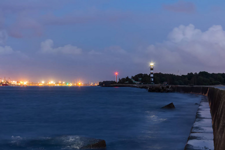 灯塔在入口处的里加港口在深夜, 在夏季