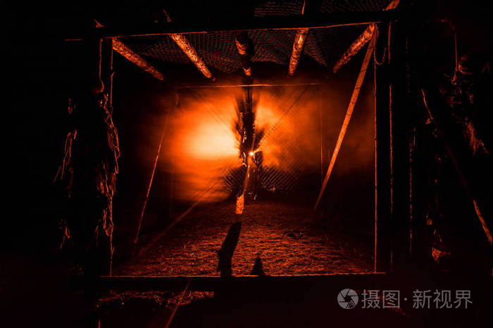 恐怖观看绞刑架上的人在夜间脚手架上的剪影与雾和色调的背景灯光.