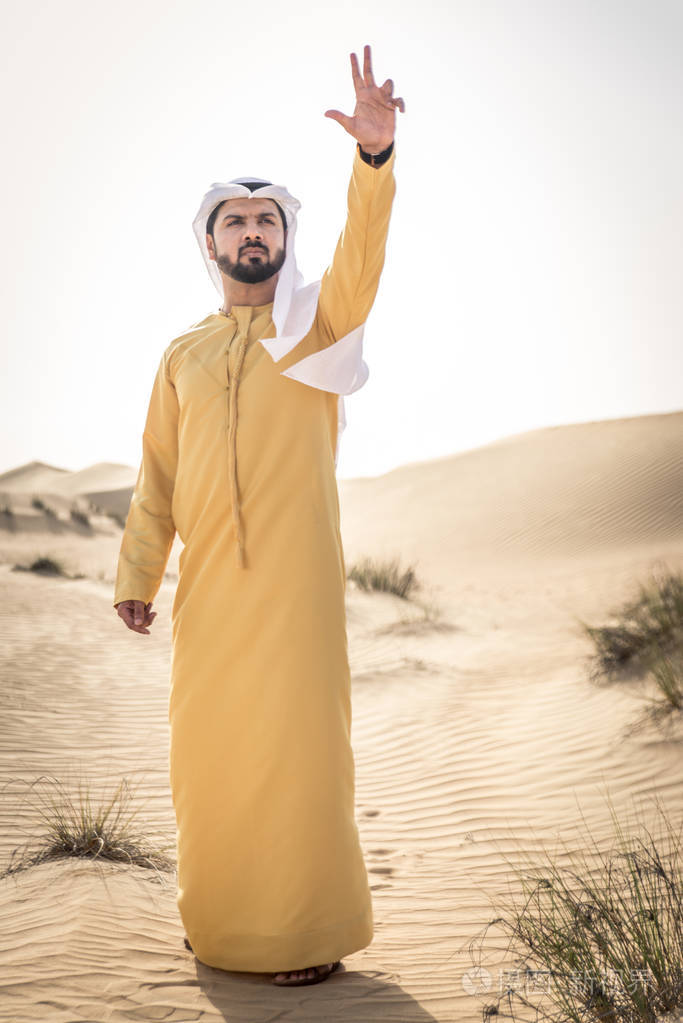 迪拜沙漠中的传统服饰的英俊阿拉伯男人